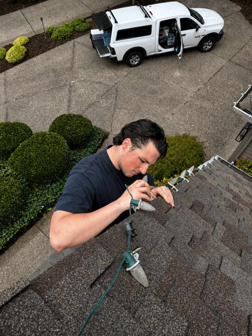 Aerial view of Halen Homes crew installing Christmas lights with company van